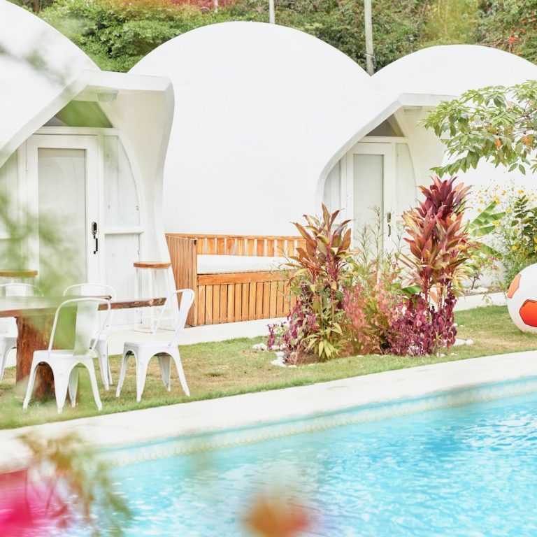 Pool Blick auf einen Pool mit Liegen und bunten Pflanzen in einem modernen Garten.