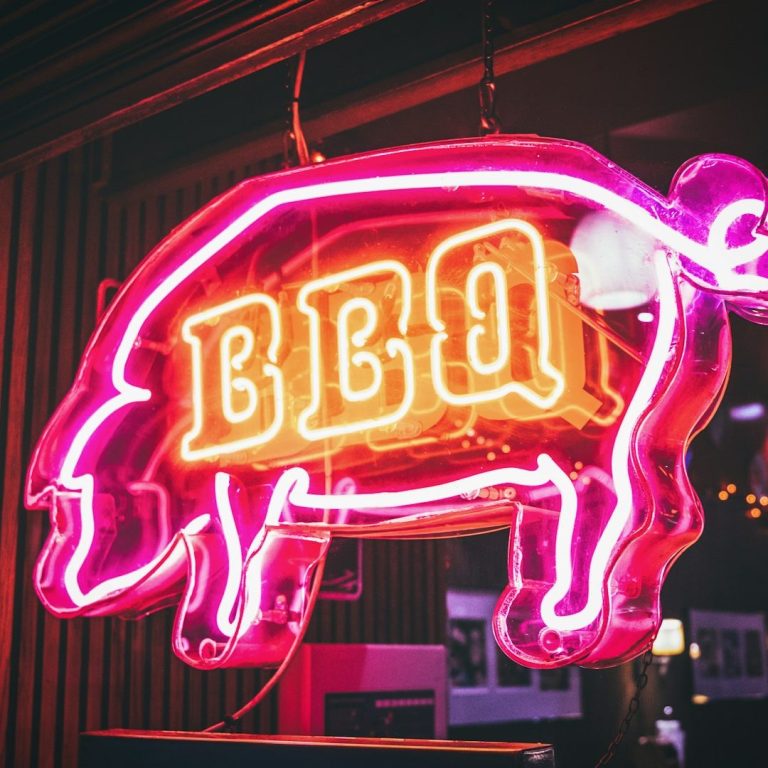 Geschenkgutschein Neonzeichen eines rosa Schweins mit der Aufschrift "BBQ".
